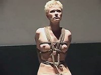 Chained latex slave girl is dildoed